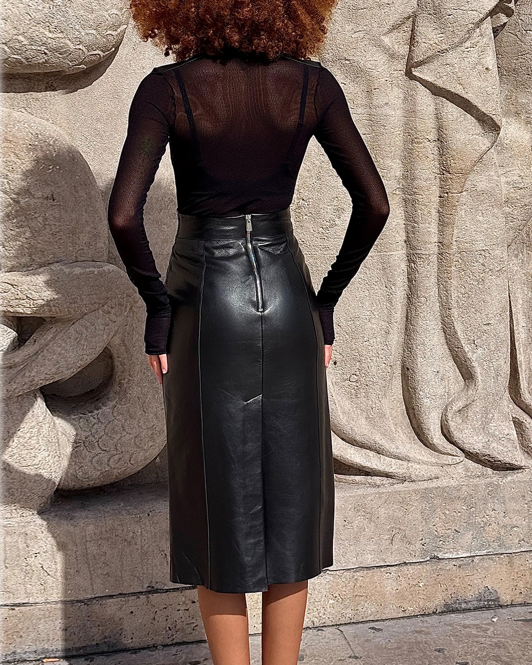 Vue de dos de la jupe crayon Eclipse en cuir noir, zip métal milieu dos apparent et surpiqué à 1 mm, signature DEA-Cult.